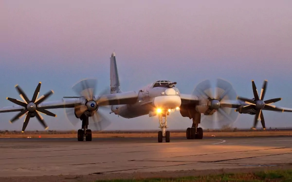 A Tupolev Tu-95 bomber aircraft prepares for takeoff on a runway, with its large propellers spinning and a twilight sky in the background, capturing a moment in military aviation.