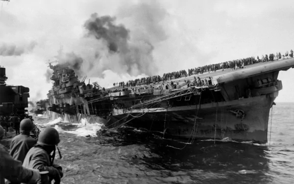 The image captures the USS Franklin (CV-13), an aircraft carrier in distress, surrounded by smoke. A glimpse into naval military history, this powerful HD wallpaper showcases wartime intensity.
