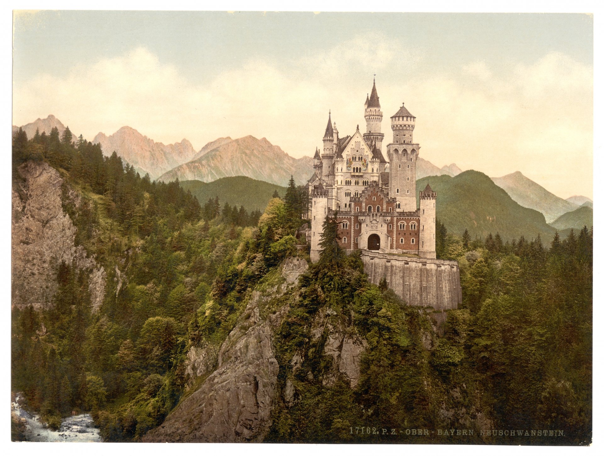 HD PC desktop wallpaper depicting the man-made Neuschwanstein Castle perched on a forested cliff with mountains in the background under a soft sky.