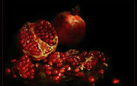 HD PC desktop wallpaper/background - food still-life of a halved pomegranate and scattered ruby seeds on a dramatic dark background.