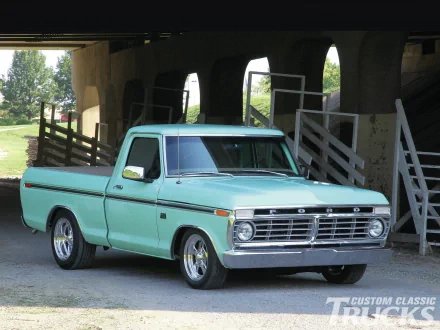 HD desktop wallpaper featuring a classic 1976 Ford F-100 pickup truck parked under a rustic wooden structure with greenery in the background.
