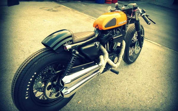 Harley-Davidson 883 cafe racer with orange tank and black frame parked on pavement — HD PC desktop wallpaper background