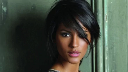 A striking HD wallpaper featuring Emanuela De Paula, showcasing her captivating gaze and stylish haircut against a textured, muted background.