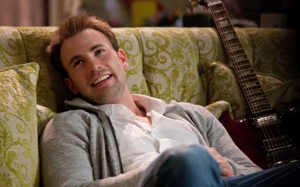 Chris Evans casually lounging on a green patterned sofa with a guitar in the background, captured in a vibrant HD wallpaper.