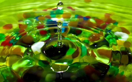 A close-up of a water drop creating ripples in a vibrant, multicolored background, capturing the beauty of nature. This HD image serves as an engaging desktop wallpaper.