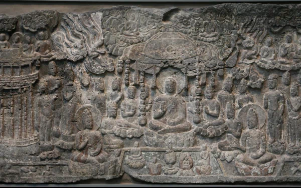 A detailed relief carving depicting Buddhist figures and symbols, showcasing the essence of Buddhism. This HD wallpaper serves as a serene backdrop for desktop use.