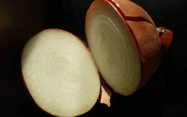 HD PC desktop wallpaper background showing two sliced onion halves with translucent rings on a black surface.