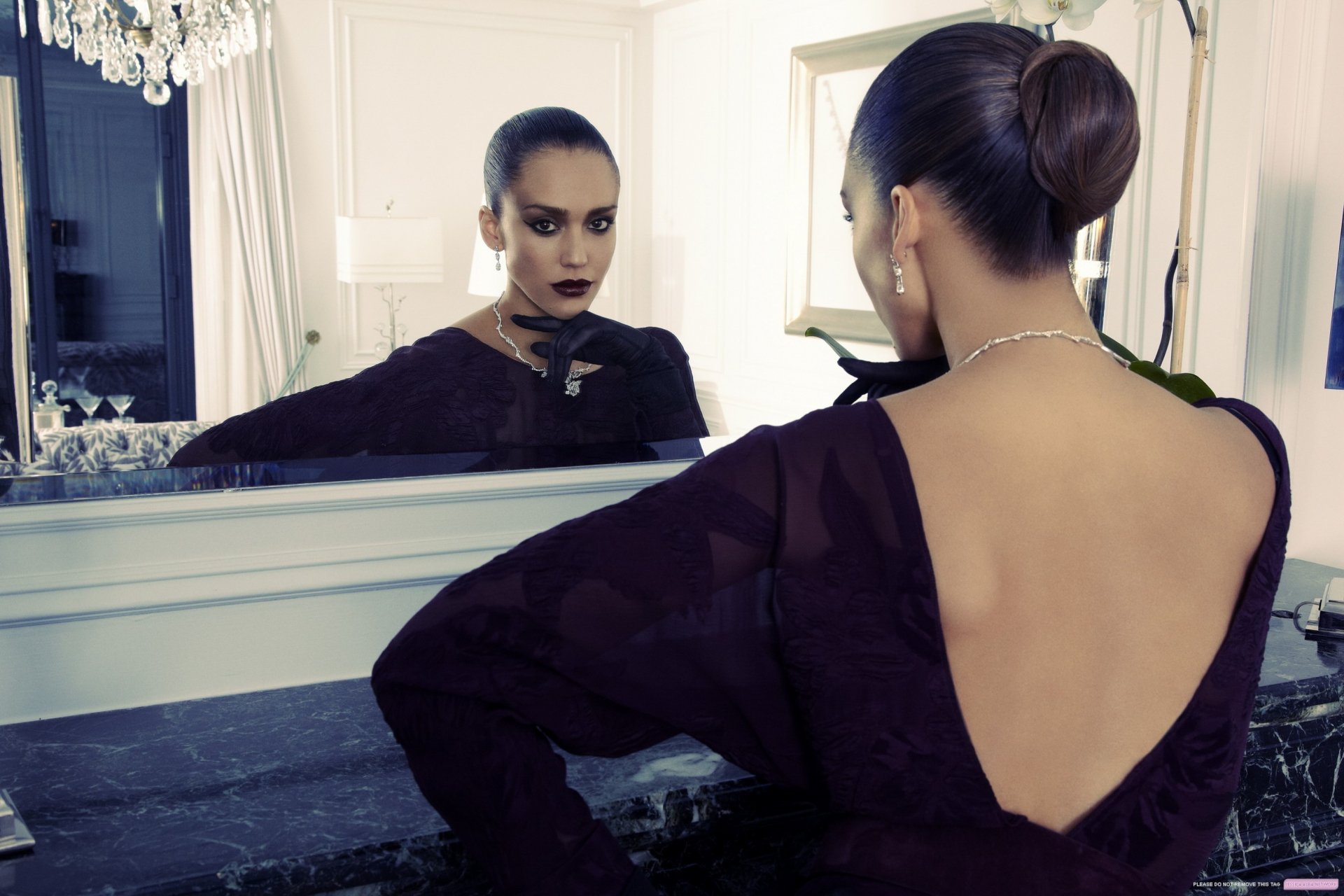 A stylish Jessica Alba poses in an elegant outfit, gazing into a mirror. This high-definition image serves as a striking desktop wallpaper and background.