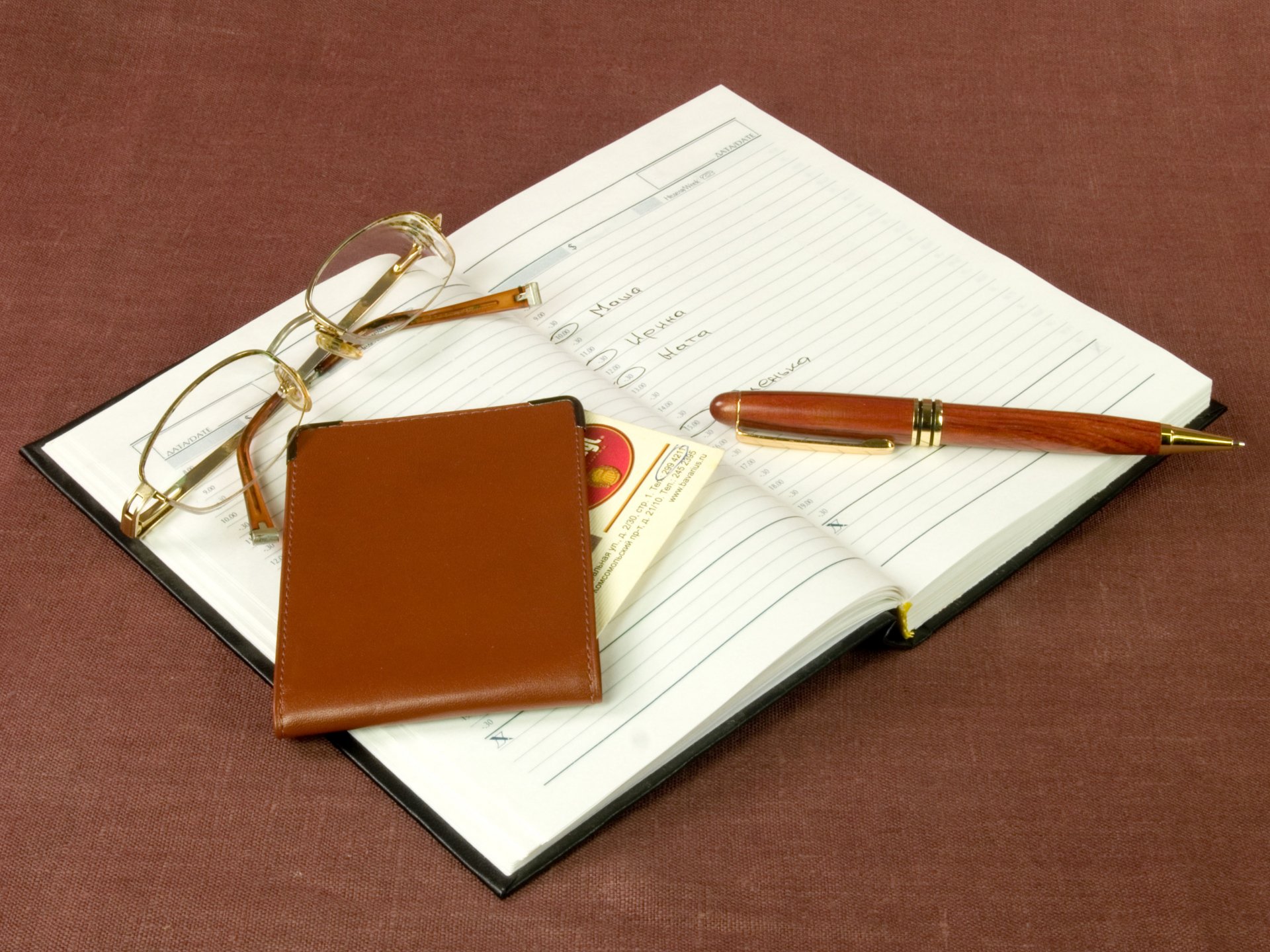 Photography — 4K Ultra HD PC desktop wallpaper/background: open planner with notes, gold-rimmed glasses, brown leather cardholder and pen on a rust-colored fabric surface.
