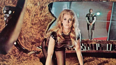HD PC desktop wallpaper from the Barbarella movie: blonde heroine in a sheer futuristic outfit kneeling inside a retro spaceship set, dramatic lighting and mirrored background.
