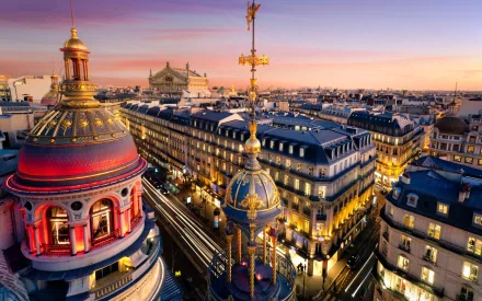 A stunning HD desktop wallpaper showcasing a majestic palace roof against a vibrant sunset sky, capturing the beauty of man-made architecture in an urban landscape.