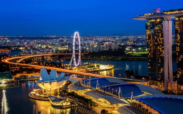 A stunning HD wallpaper showcasing the vibrant skyline of Singapore at dusk, featuring the Marina Bay Sands, the Singapore Flyer, and the futuristic ArtScience Museum, illuminated against the night sky.