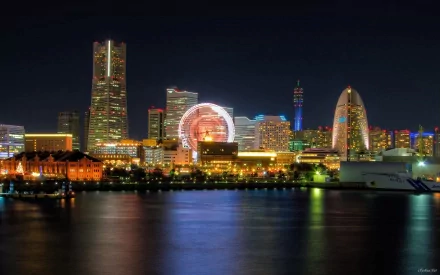 HD desktop wallpaper of Yokohama's illuminated man-made skyline at night, reflecting on the calm water.