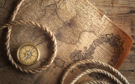 Vintage compass resting on an old map beside coiled rope, captured as a high-definition PC desktop wallpaper and background.