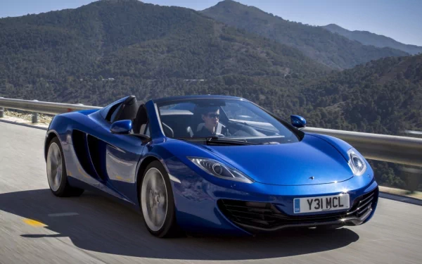 Blue McLaren MP4-12C Spider supercar driving on a mountain road, captured in HD for a striking PC desktop wallpaper background.