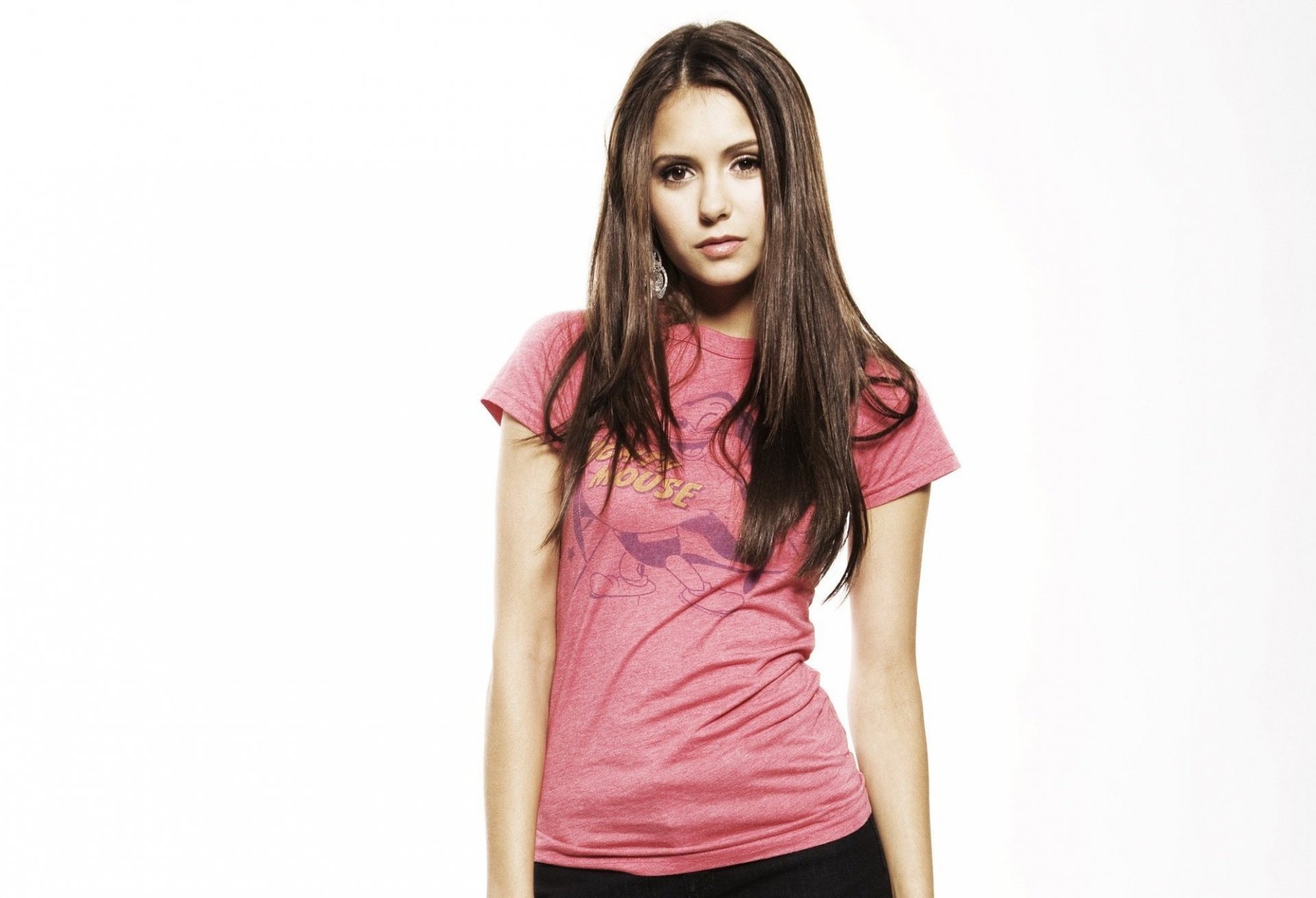 Nina Dobrev poses confidently in a pink t-shirt, captured in a high-definition PC desktop wallpaper and background.