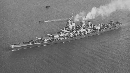 Aerial view of the USS Iowa (BB-61), a historic battleship, showcasing its impressive military design as it navigates through the water. Black and white HD wallpaper for desktop use.