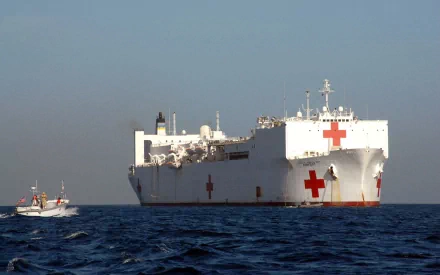 USNS Comfort (T-AH-20) naval hospital ship/warship at sea, white military medical vessel marked with red crosses, shown as a 2K Quad HD desktop wallpaper/background.