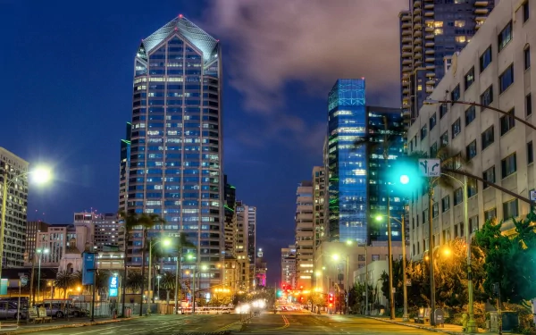 Nighttime cityscape of San Diego with illuminated skyscrapers and streetlights, captured in HD as a vibrant man-made urban scene.