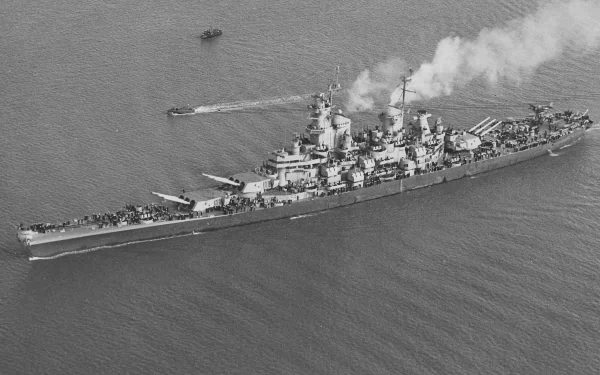 Aerial view of the USS Iowa (BB-61), a historic battleship, showcasing its impressive military design as it navigates through the water. Black and white HD wallpaper for desktop use.