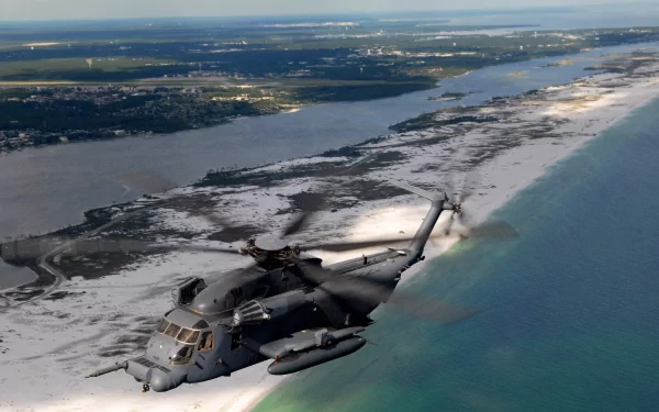 Sikorsky MH-53 military helicopter flying low over a sandy coastline, aerial view — 2K Quad HD PC desktop wallpaper/background.