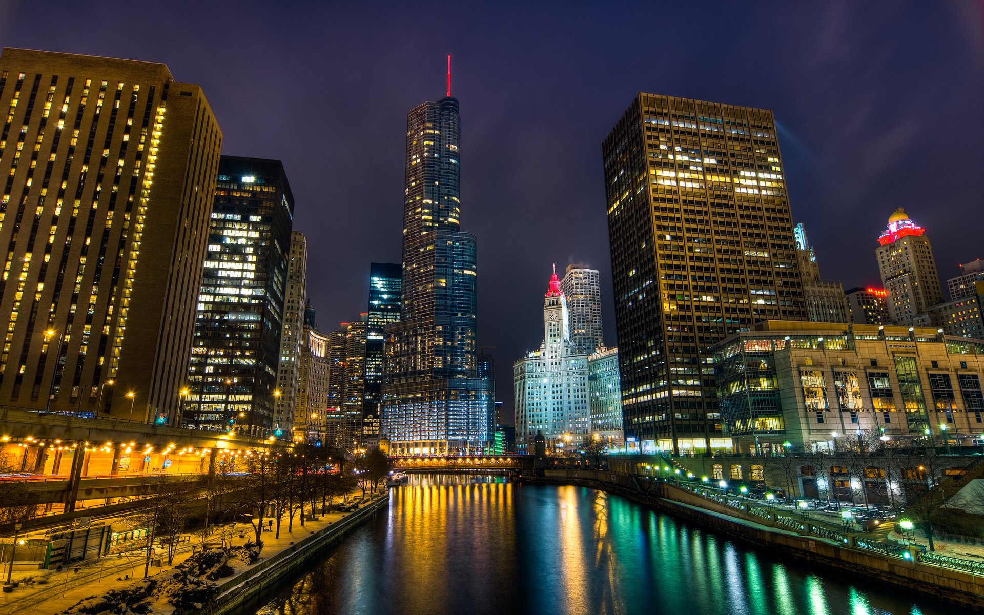 Man-made Chicago skyline at night, glowing skyscrapers reflected in the river; vibrant, high-definition PC desktop wallpaper/background.