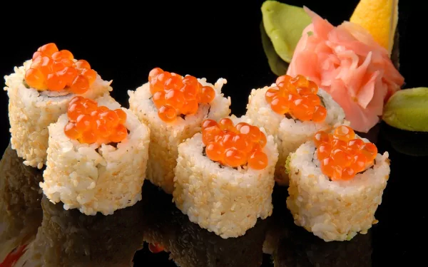 Close-up of sushi rolls topped with bright orange fish roe, presented with pickled ginger and wasabi on a reflective black surface, captured in 4K Ultra HD.