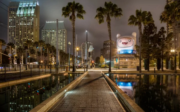 Nighttime view of San Diego's urban skyline with palm trees lining a reflecting pool in this HD man-made cityscape wallpaper.