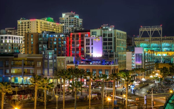 Man-made San Diego waterfront at night: colorful lit buildings and palm-lined streets, 2K Quad HD PC desktop wallpaper/background.