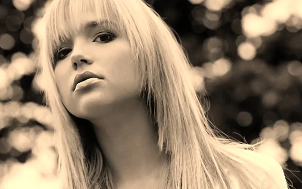 HD desktop wallpaper of Arielle Kebbel, showcasing a woman with long, straight blonde hair, gazing at the camera with a blurred, bokeh background.
