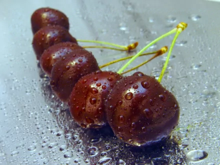 HD PC desktop wallpaper featuring a close-up of fresh cherries with water droplets on a reflective surface.