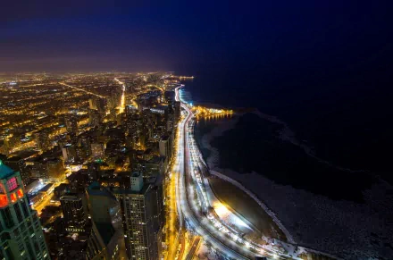 A breathtaking HD desktop wallpaper showcasing the cityscape of Chicago at night, featuring illuminated buildings along Lake Michigan and the shimmering waterfront.