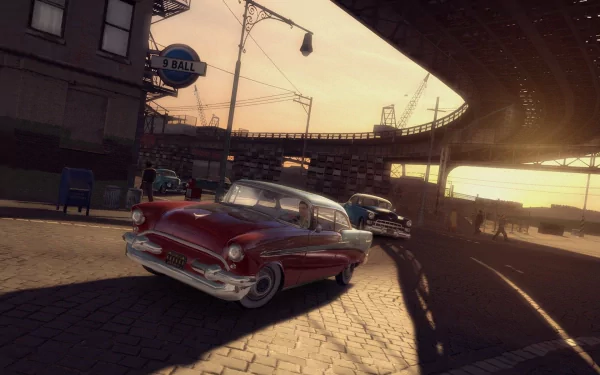 This HD desktop wallpaper from Mafia II features a vintage car driving through a sunlit, urban street scene under an elevated train track.