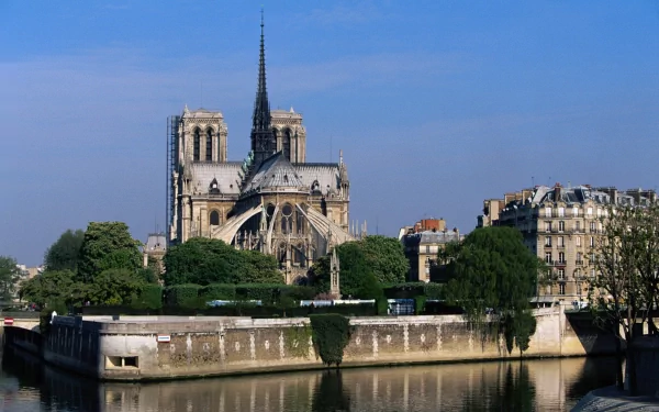 Religious HD PC desktop wallpaper and background featuring Notre-Dame de Paris cathedral on the Île de la Cité, with the Seine riverfront and classic Parisian buildings.