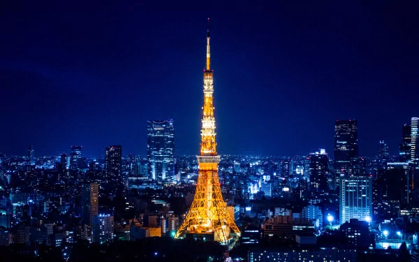 Night cityscape of Tokyo, Japan with the illuminated man-made Tokyo Tower rising above skyscrapers — 2K Quad HD PC desktop wallpaper and background.