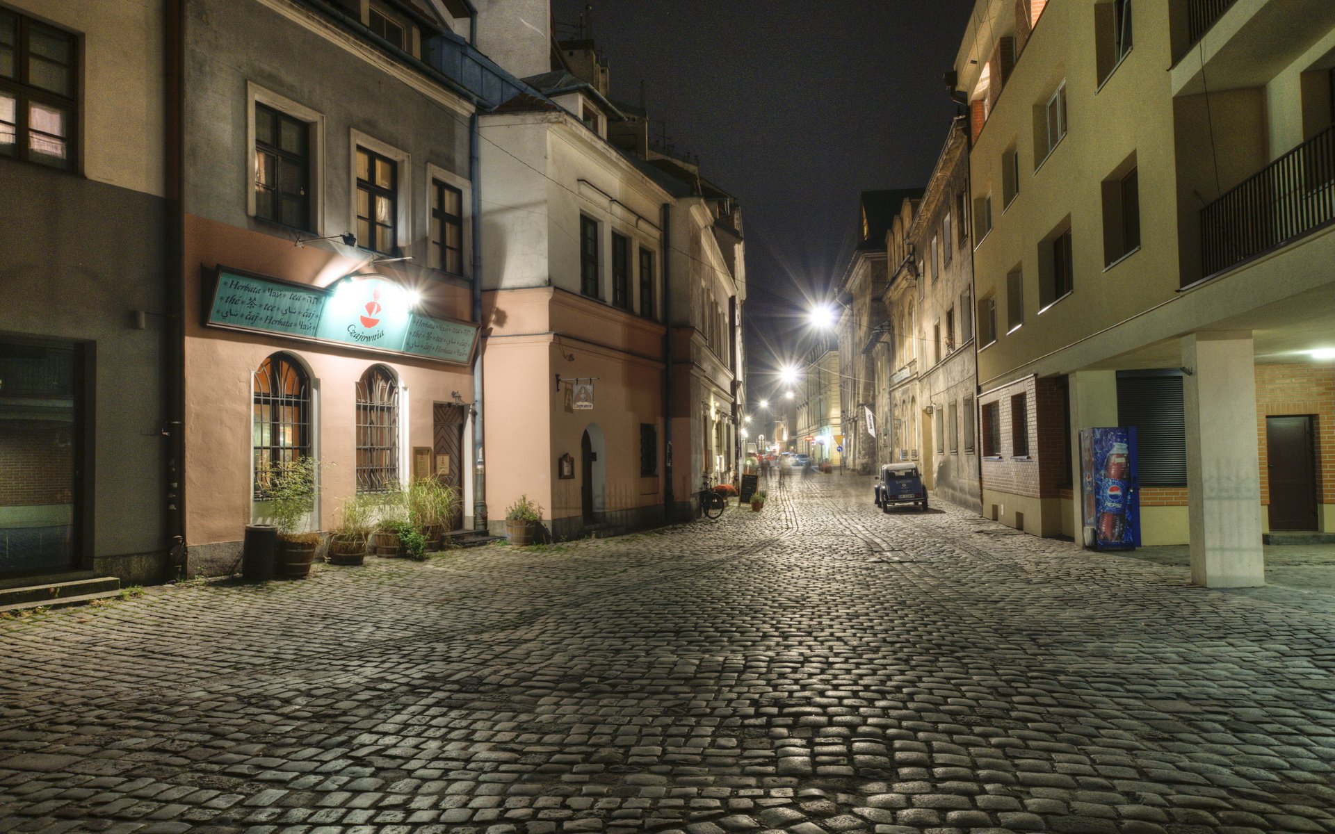 HD PC desktop wallpaper background: man-made cobblestone village street at night with historic buildings and warm streetlights.