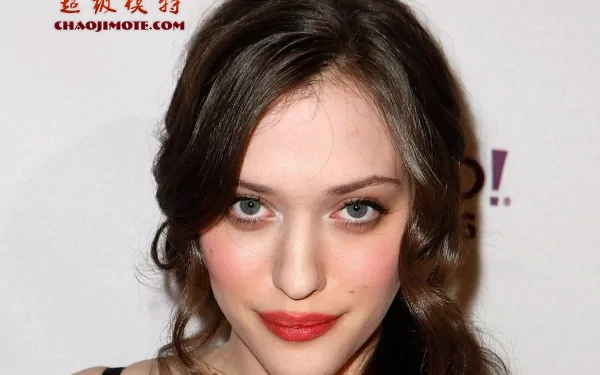 HD PC desktop wallpaper featuring a close-up portrait of celebrity Kat Dennings with soft makeup and wavy dark hair against a simple background.