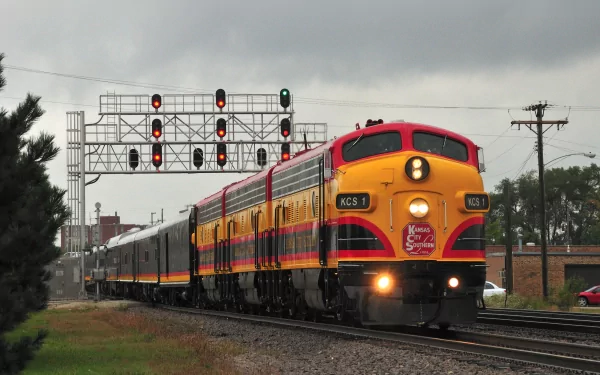 HD desktop wallpaper showing a colorful vintage train engine traveling on tracks under a cloudy sky, framed by signal lights and surrounding greenery.