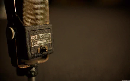 A close-up of a vintage microphone against a blurred background, capturing the essence of music. This HD desktop wallpaper adds a creative touch to your digital space.