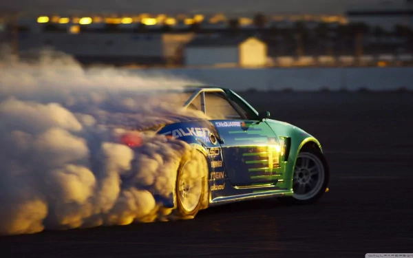A Nissan 350Z drifts dramatically, leaving a cloud of smoke on the track during sunset, showcasing its sleek design and powerful performance in this HD desktop wallpaper.