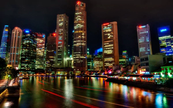 HD desktop wallpaper showcasing Singapore's vibrant man-made skyline illuminated against the night sky, reflecting colorful lights on the water.