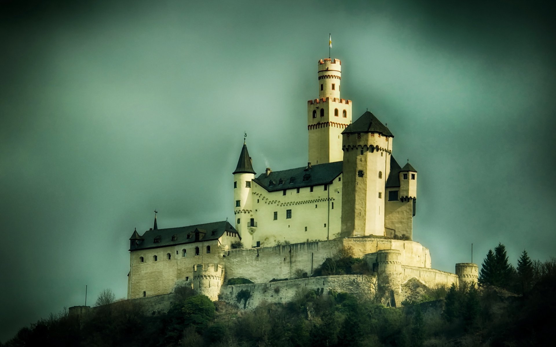 A majestic castle rises against a moody sky, showcasing intricate architecture and a timeless presence, making it an impressive HD desktop wallpaper.