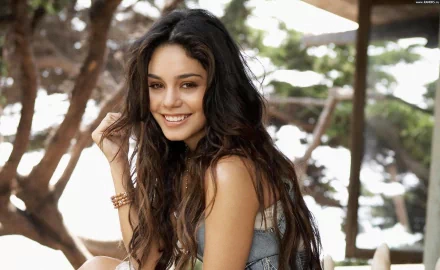Vanessa Hudgens smiles warmly in this HD wallpaper, surrounded by nature. The image captures her vibrant energy and captivating presence, making it a striking desktop background.