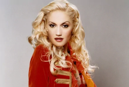 HD desktop wallpaper featuring Gwen Stefani with platinum blonde hair and a red jacket, highlighting her iconic music style and bold presence.