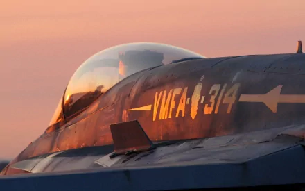 A close-up of a military jet fighter, highlighting its sleek design and markings, set against a vibrant sunset, creating a stunning HD desktop wallpaper.