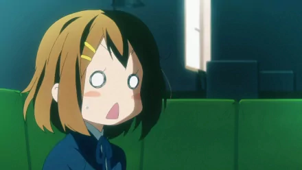 HD PC desktop wallpaper featuring an anime character from K-ON! with a surprised expression, set against a dimly lit room background.