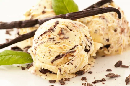 Delicious vanilla ice cream with chocolate chunks, garnished with mint leaves and vanilla pods, captured in stunning 4K Ultra HD for a vibrant desktop wallpaper.