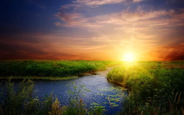 A serene sunrise over lush green fields and a winding river, capturing the beauty of nature in vivid colors. High-definition wallpaper for a tranquil desktop background.