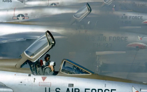 HD PC desktop wallpaper of U.S. Air Force Republic F-105 Thunderchiefs, close-up of an open cockpit with aircrew and nearby fuselages bearing USAF markings.