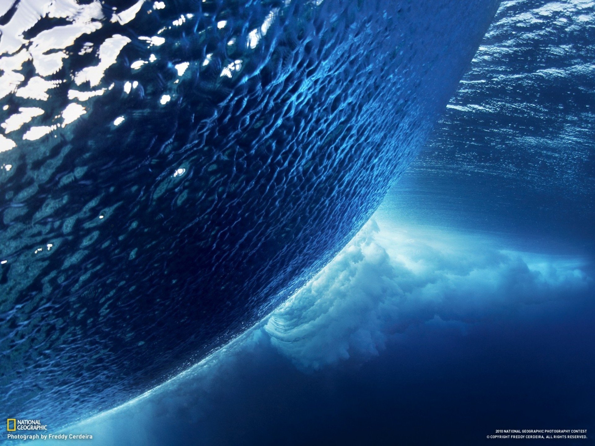HD PC desktop wallpaper showcasing a powerful ocean wave from beneath the water’s surface, capturing the dynamic beauty of nature.